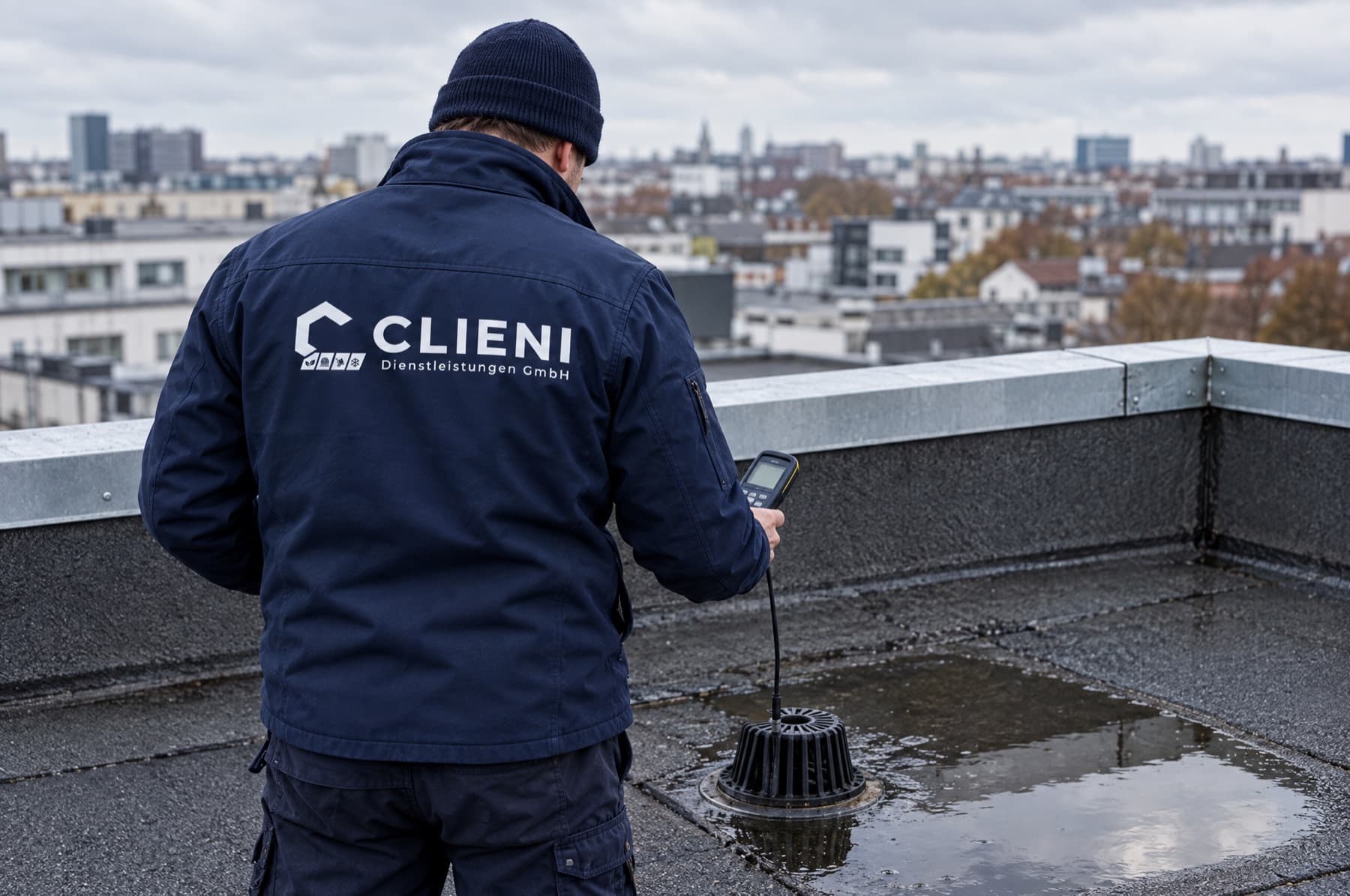 CLIENI Monteur prüft einen Dachgully bei der Leckortung auf einem Berliner Flachdach